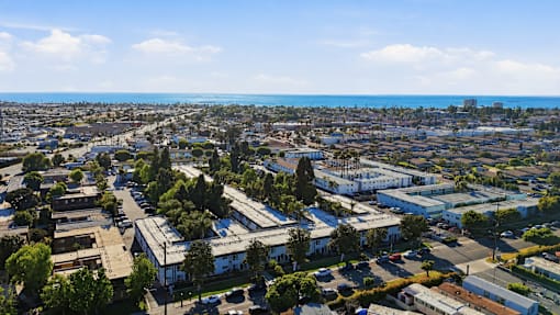 A cityscape with buildings and trees under a clear sky.