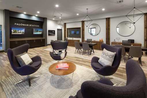 A modern lounge area with comfortable chairs and a television.