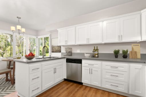 a kitchen with white cabinets and a stainless steel dishwasher at Orange Grove Circle, Pasadena, California
