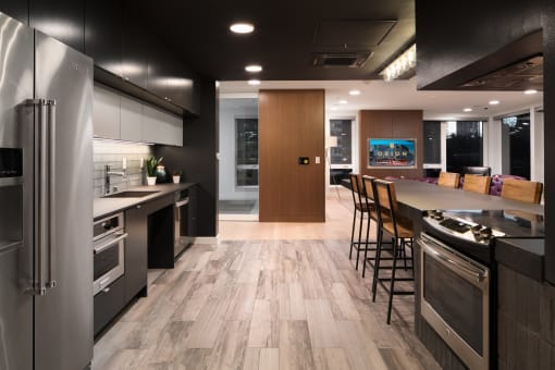 a kitchen with stainless steel appliances and a large island with chairs