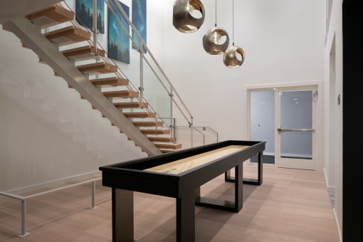 a ping pong table in a living room next to stairs