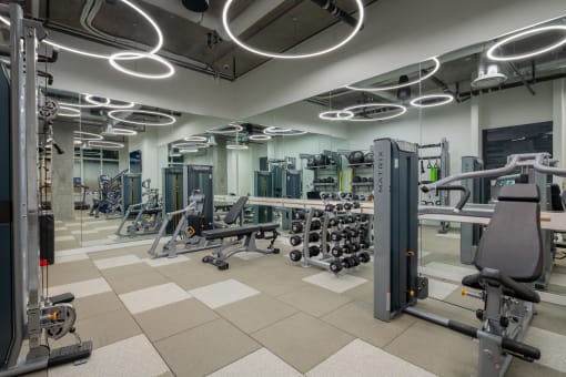 a gym with weights and cardio equipment in a building