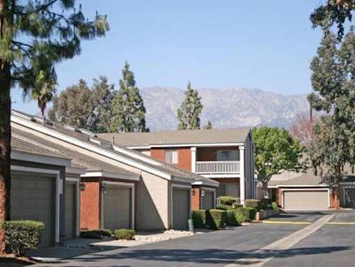 A row of houses with garages and a mountain in the background.