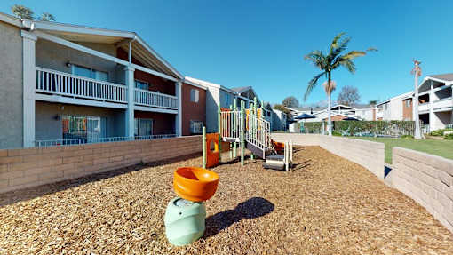 A playground with a slide and a green toy in the foreground.