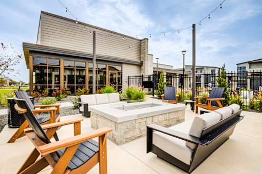 A patio with a hot tub and chairs.