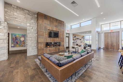 A modern living room with a stone fireplace and a large sectional sofa.