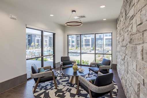 A room with a stone wall and a table with chairs.