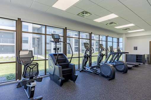 A gym with treadmills, elliptical machines, and other exercise equipment.