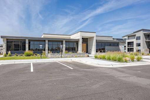 A modern building with a parking lot in front.