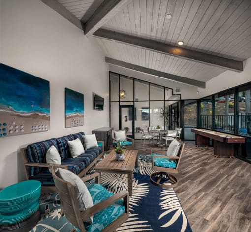 a room with a couch and chairs and a table with shuffleboard