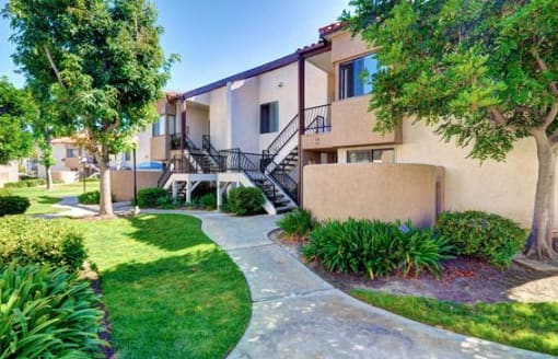 A building with a staircase and a tree in front of it at The Casas Apartments, San Diego, California