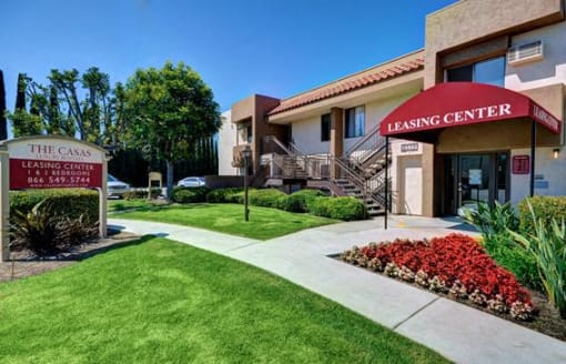 The Casas Leasing Center is a building with a red awning and a sign in front of it at The Casas Apartments, San Diego, CA