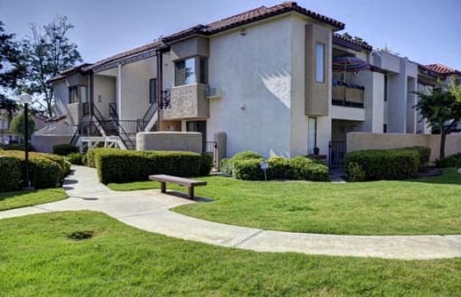 Apartment complex with a green lawn and a bench at The Casas Apartments, California, 92126