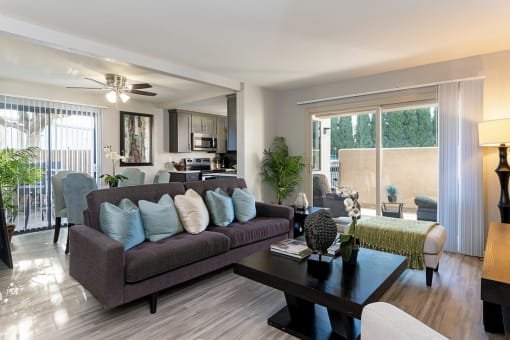 A living room with a brown couch and a coffee table at The Casas Apartments, San Diego