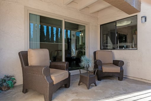 Two chairs and a table are on a patio at The Casas Apartments, San Diego, 92126