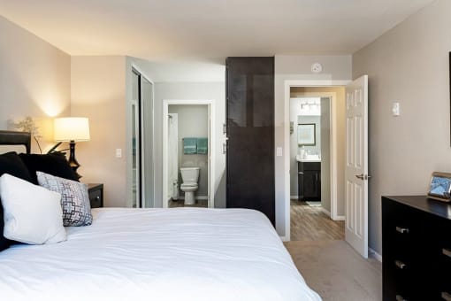 A bedroom with a large bed and a black dresser at The Casas Apartments, California