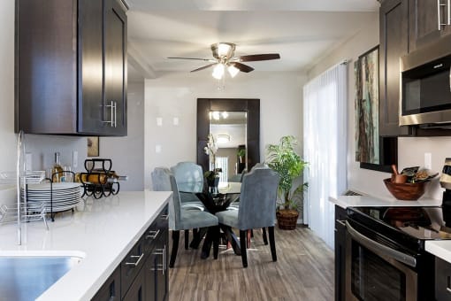 A kitchen with a dining table and chairs at The Casas Apartments, San Diego, CA