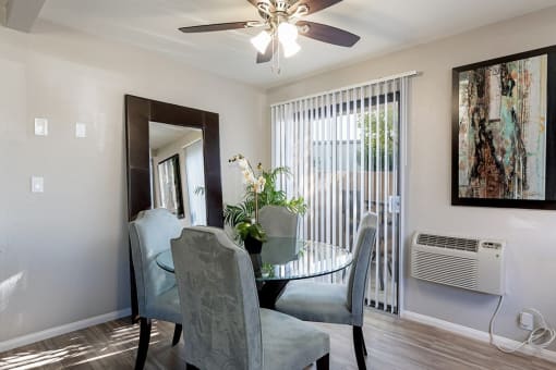 A dining room with a glass table and chairs at The Casas Apartments, San Diego
