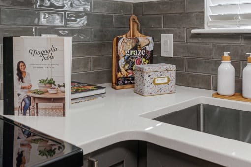 a kitchen counter with a sink and a book on the counter