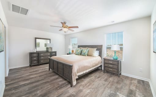 a bedroom with a ceiling fan and a large bed