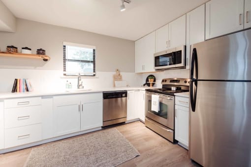 a kitchen with white cabinets and stainless steel appliances