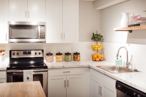 a kitchen with white cabinets and stainless steel appliances