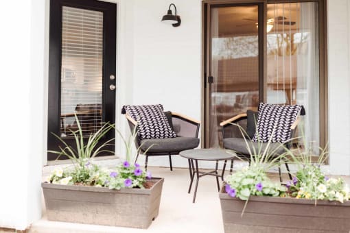 a patio with two chairs and a coffee table