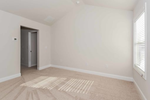 another bedroom with white walls and carpet