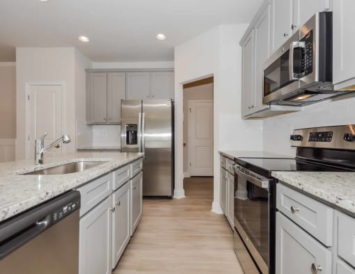 a kitchen with white cabinets and stainless steel appliances