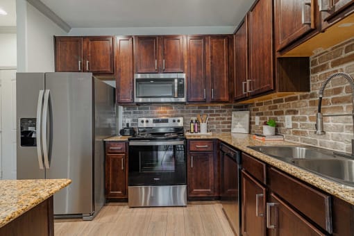 Kitchen with wooden cabinets at Auxo at Memorial, Houston, 77024