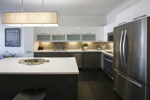a modern kitchen with stainless steel appliances and white counter tops