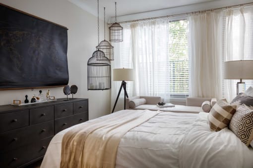 a bedroom with a bed and a dresser and two bird cages
