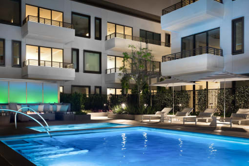 a swimming pool in front of a building with a pool
