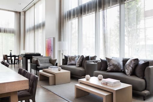 a living room with couches and tables and large windows