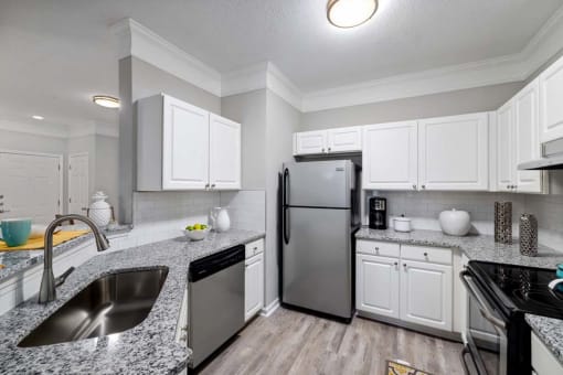 a kitchen with white cabinets and a stainless steel refrigerator