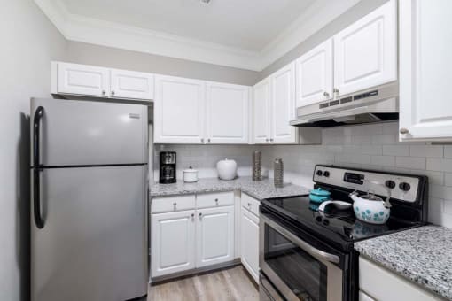 a kitchen with stainless steel appliances and white cabinets