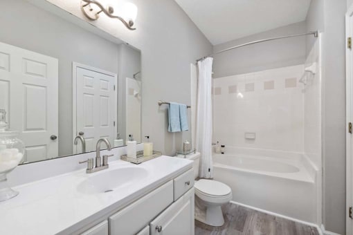 a white bathroom with two sinks and a toilet