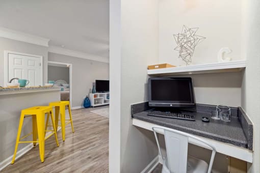 a kitchen and a living room with a desk and a computer