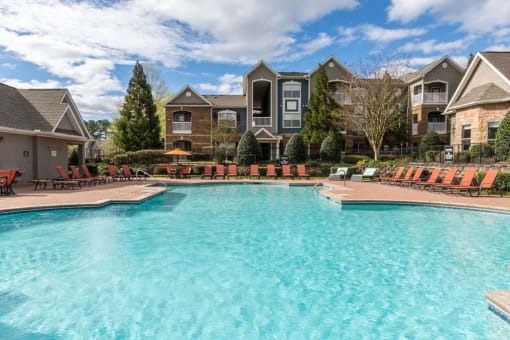 a large swimming pool with apartments in the background