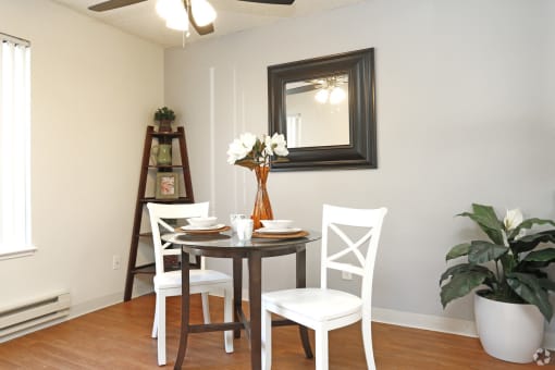 a dining room with a table and chairs and a mirror