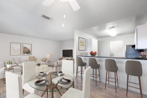 a living room and dining room with a glass table and chairs