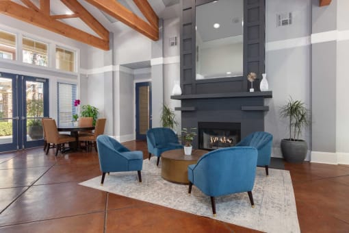 a living room with blue chairs and a fireplace