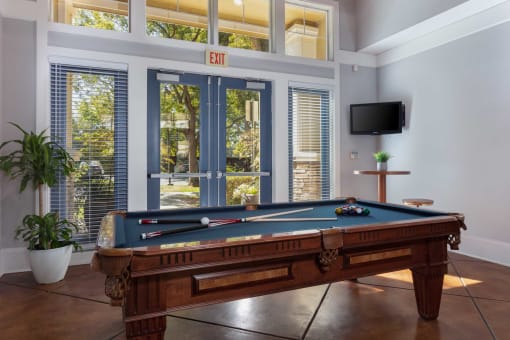a pool table in a living room with a tv