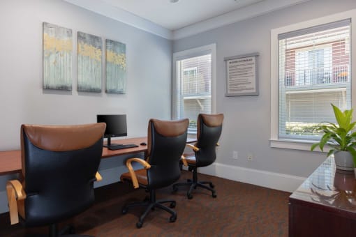an office with three chairs and a desk with a computer