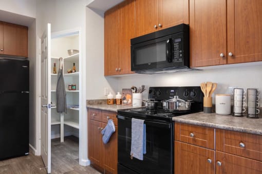 a kitchen with black appliances and wooden cabinets