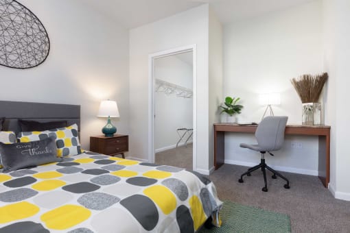 a bedroom with a bed and a desk with a chair