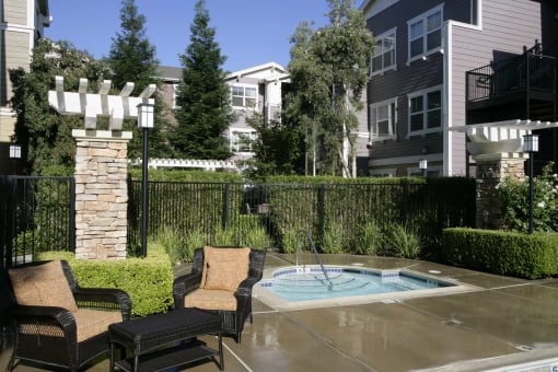 a hot tub in a backyard with patio furniture
