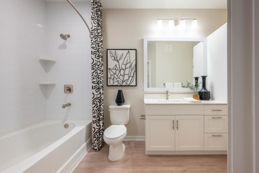 a white bathroom with a shower curtain and a toilet and a sink