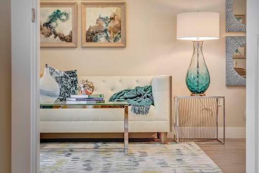 a living room with a couch and a table with a lamp