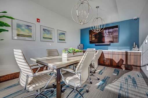a conference room with a table and chairs and a chandelier